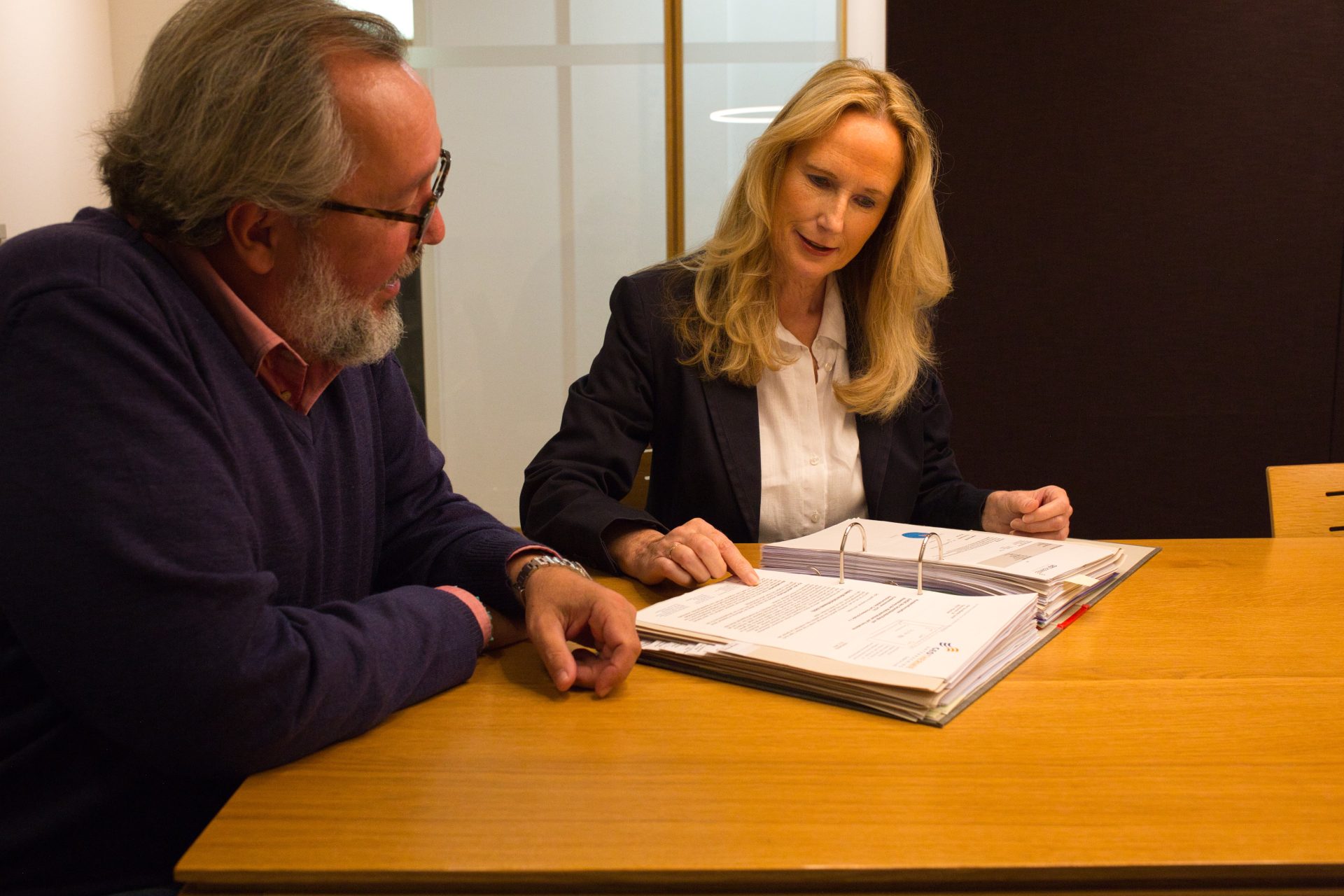 Zwei Personen sitzen an einem Holztisch
